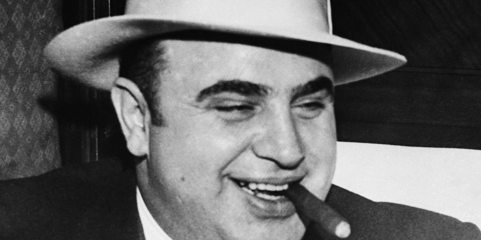 Retrato de Al Capone, um dos mais notórios gângsteres da era da Lei Seca. Capone enriqueceu com o contrabando e a venda ilegal de álcool, tornando-se um símbolo da criminalidade organizada que floresceu durante a proibição.