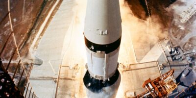 O poderoso foguete Saturn V impulsiona a missão Apollo 11 para o espaço em 16 de julho de 1969, marcando o início de uma jornada histórica rumo à Lua. A imagem captura a grandiosidade do lançamento, com a fumaça e o fogo dos propulsores dominando a cena. Fonte: NASA.