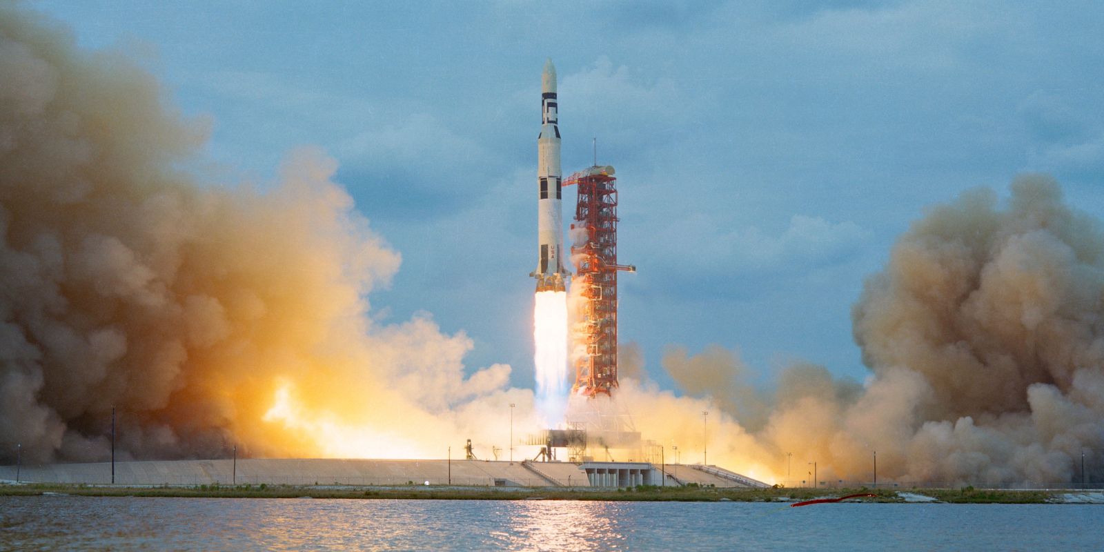O imponente foguete Saturn V, com 111 metros de altura, aguarda na plataforma de lançamento 39A no Centro Espacial Kennedy, pronto para impulsionar a missão Apollo 11 rumo à Lua. Esta imagem destaca a escala monumental da engenharia envolvida na conquista espacial. Fonte: Space.com.
