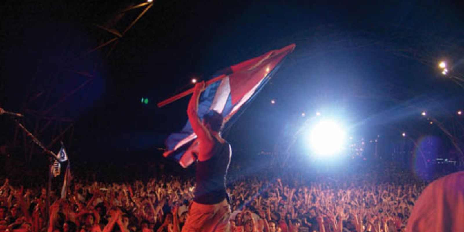 Chris Cornell segura uma bandeira cubana durante o show do Audioslave em Havana, criando uma conexão íntima com os fãs cubanos. A interação entre a banda e o público foi um elemento crucial na atmosfera de união e celebração da noite.