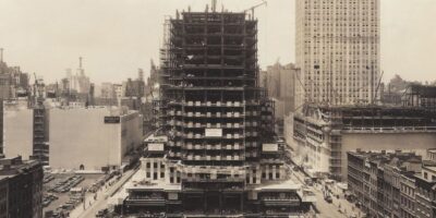 Uma vista aérea da construção do Rockefeller Center em seus estágios iniciais, mostrando a grandiosidade do projeto que transformaria o horizonte de Nova York. Esta imagem destaca o esforço monumental e a escala da obra durante a década de 1930. Fonte: Rockefeller Center.