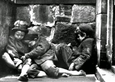Crianças dormem nas ruas da Mulberry Street, em Nova York, por volta de 1890. Esta imagem, capturada por Jacob Riis, ilustra a dura realidade da pobreza infantil e as condições precárias de vida enfrentadas por muitas famílias imigrantes na cidade. Fonte: Jacob Riis / Museum of the City of New York.