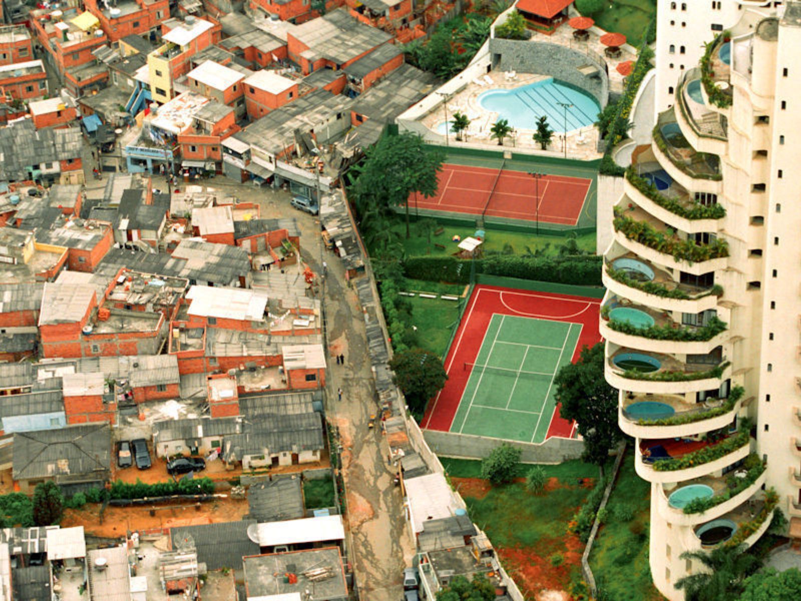 Em 2003, o fotógrafo Tuca Vieira capturou uma imagem que se tornou emblemática da desigualdade social em São Paulo. A foto mostra um luxuoso condomínio no bairro Morumbi contrastando diretamente com a comunidade Paraisópolis. Em 2003, o fotógrafo Tuca Vieira capturou uma imagem que se tornou emblemática da desigualdade social em São Paulo. A foto mostra um luxuoso condomínio no bairro Morumbi contrastando diretamente com a comunidade Paraisópolis.