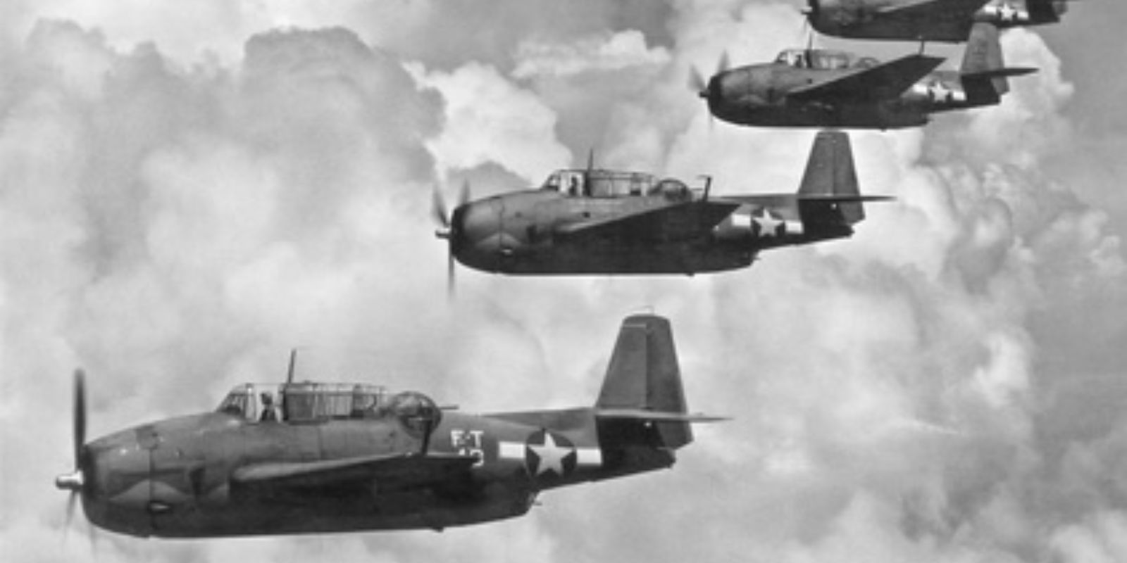 Os cinco torpedeiros Grumman Avenger da Esquadrilha 19 voam em formação sobre o Oceano Atlântico. A imagem, capturada durante um exercício de treinamento, mostra a precisão e a habilidade dos pilotos da Marinha dos EUA. No entanto, em 5 de dezembro de 1945, essa mesma formação desapareceria misteriosamente no Triângulo das Bermudas. Fonte: National Archives.