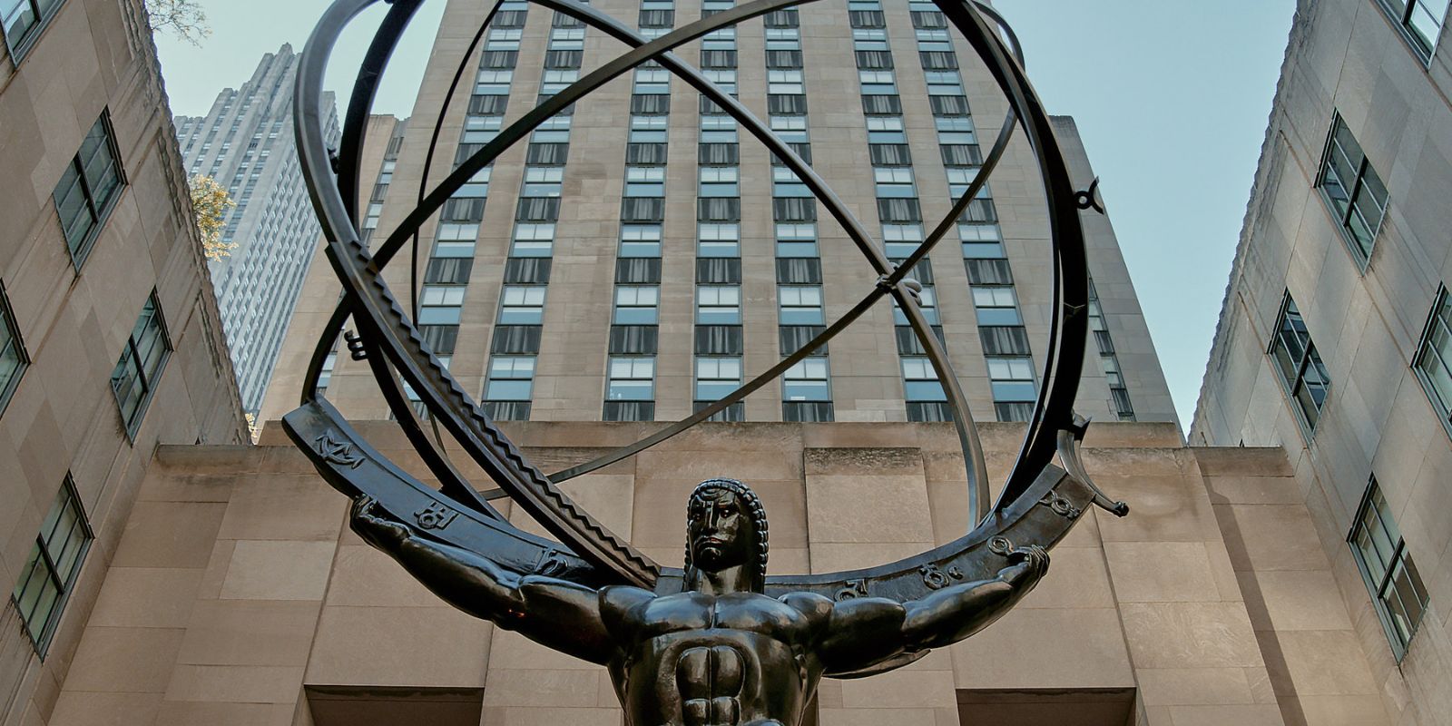 A imponente estátua de Atlas, de Lee Lawrie, em frente ao International Building do Rockefeller Center. Esta obra de arte Art Deco, com 45 pés de altura, representa Atlas carregando o cosmos e é um dos símbolos mais reconhecíveis do complexo. Fonte: The New York Times.