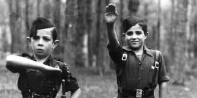 Durante o conflito, os nacionalistas de Franco aderiram amplamente ao fascismo, influenciados tanto pelo contexto europeu da época quanto pela necessidade de aliar-se a potências como a Alemanha de Hitler e a Itália de Mussolini. Na imagem, duas crianças leais ao General Francisco Franco fazem a saudação militar fascista durante a Guerra Civil Espanhola.