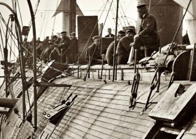 USS Galena após a Batalha de Drewry's Bluff em 15 de maio de 1862. A fotografia mostra o convés perfurado com três grandes buracos visíveis no casco de madeira. Tripulantes caminham entre os destroços enquanto canhões Dahlgren permanecem em posição. O navio foi atingido 44 vezes durante o bombardeio de Fort Darling, expondo a inadequação de sua blindagem de apenas 79 milímetros. Esta imagem histórica captura o momento em que a Marinha dos EUA aprendeu lições dolorosas sobre proteção naval. Fonte: James F. Gibson / Library of Congress / U.S. Naval Historical Center