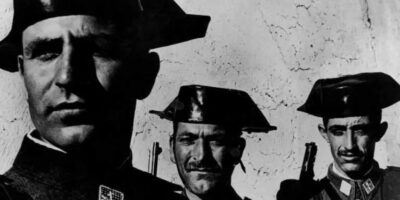 Os homens de aparência severa na imagem são os policiais rurais (Guarda Civil) do General Francisco Franco, ditador que ascendeu após triunfar na Guerra Civil Espanhola e governou a Espanha com mão de ferro entre 1939 e 1975. Tais homens eram responsáveis pela lei nacional e patrulhavam o campo, onde eram temidos pelas pessoas nas aldeias e vilarejos, locais muito vigiados pela ditadura espanhola e onde também havia polícia local.