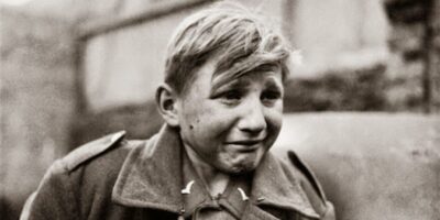 Esta é a icônica fotografia de Hans-Georg Henke, um menino soldado alemão de 16 anos, capturado pelas forças americanas em 1945. Sua imagem, com o rosto coberto de lágrimas e fuligem, tornou-se um símbolo pungente da devastação e do desespero que a Segunda Guerra Mundial infligiu à juventude. A foto foi tirada por John Florea, da revista Life. Fonte: John Florea/Life Magazine.