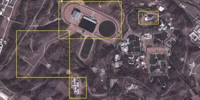 Imagem de satélite de alta resolução capturada em 2012 revela detalhes do complexo Kang Dong. Visível estão o edifício principal ao redor de um lago com fonte ornamental, múltiplas residências para membros da família Kim, instalações esportivas incluindo campo de futebol e hipódromo, além das duas linhas de segurança que cercam todo o perímetro de 4 quilômetros quadrados. Fonte: North Korea Economy Watch / Google Earth