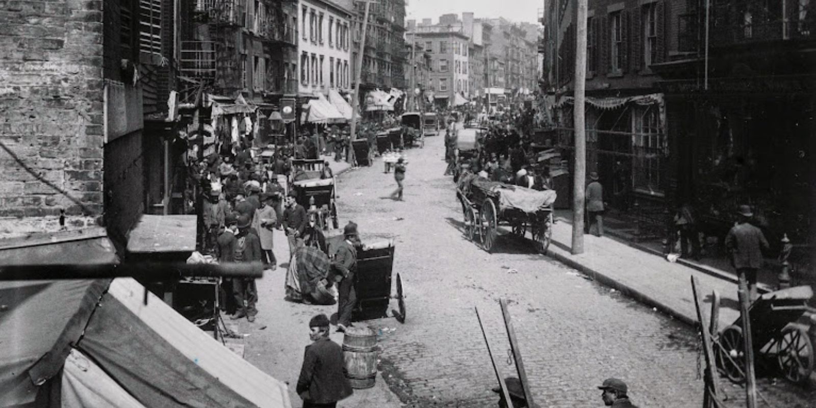 Uma vista do Lower East Side de Manhattan, por volta de 1890, mostrando a densidade populacional e as características urbanas da área onde muitos imigrantes se estabeleceram. A imagem de Jacob Riis contextualiza o ambiente de vida da época. Fonte: Jacob A. Riis, © Bettmann/CORBIS.