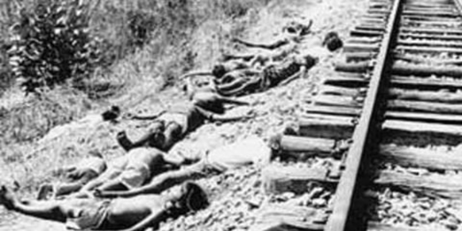Corpos de vítimas da seca, abandonados ao lado de uma ferrovia, um triste testemunho da escala da tragédia. A imagem choca ao revelar a desesperança e a falta de recursos para enterrar os mortos, que se acumulavam nas estradas e ferrovias por onde os retirantes tentavam fugir da fome.