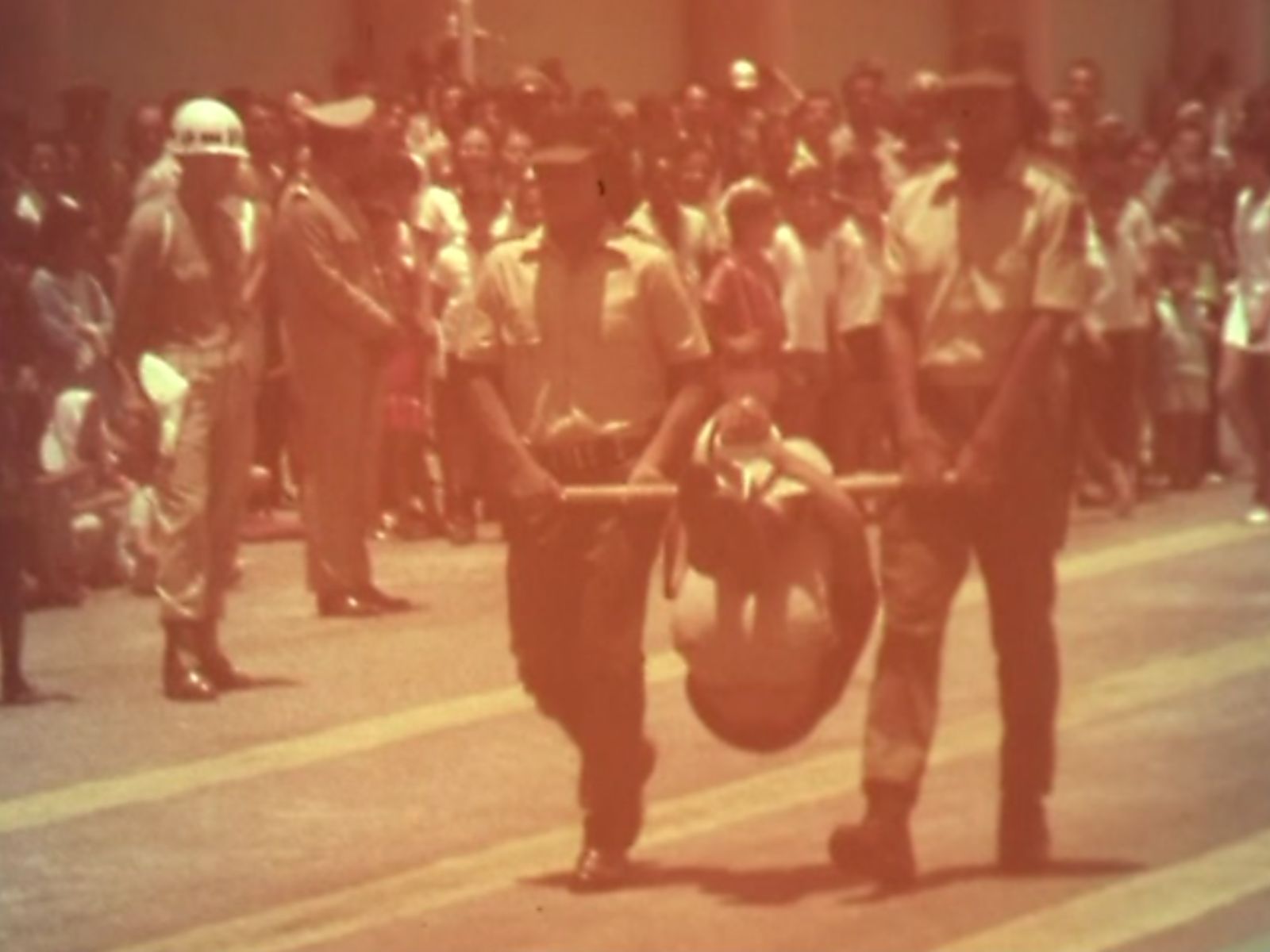 Durante a parada militar em Belo Horizonte, a primeira turma de alunos da Guarda Rural Indígena se formava. Um homem era carregado em um “pau-de-arara”. Esse era um dos instrumentos de tortura mais usados na época. Durante a parada militar em Belo Horizonte, a primeira turma de alunos da Guarda Rural Indígena se formava. Um homem era carregado em um "pau-de-arara". Esse era um dos instrumentos de tortura mais usados na época.