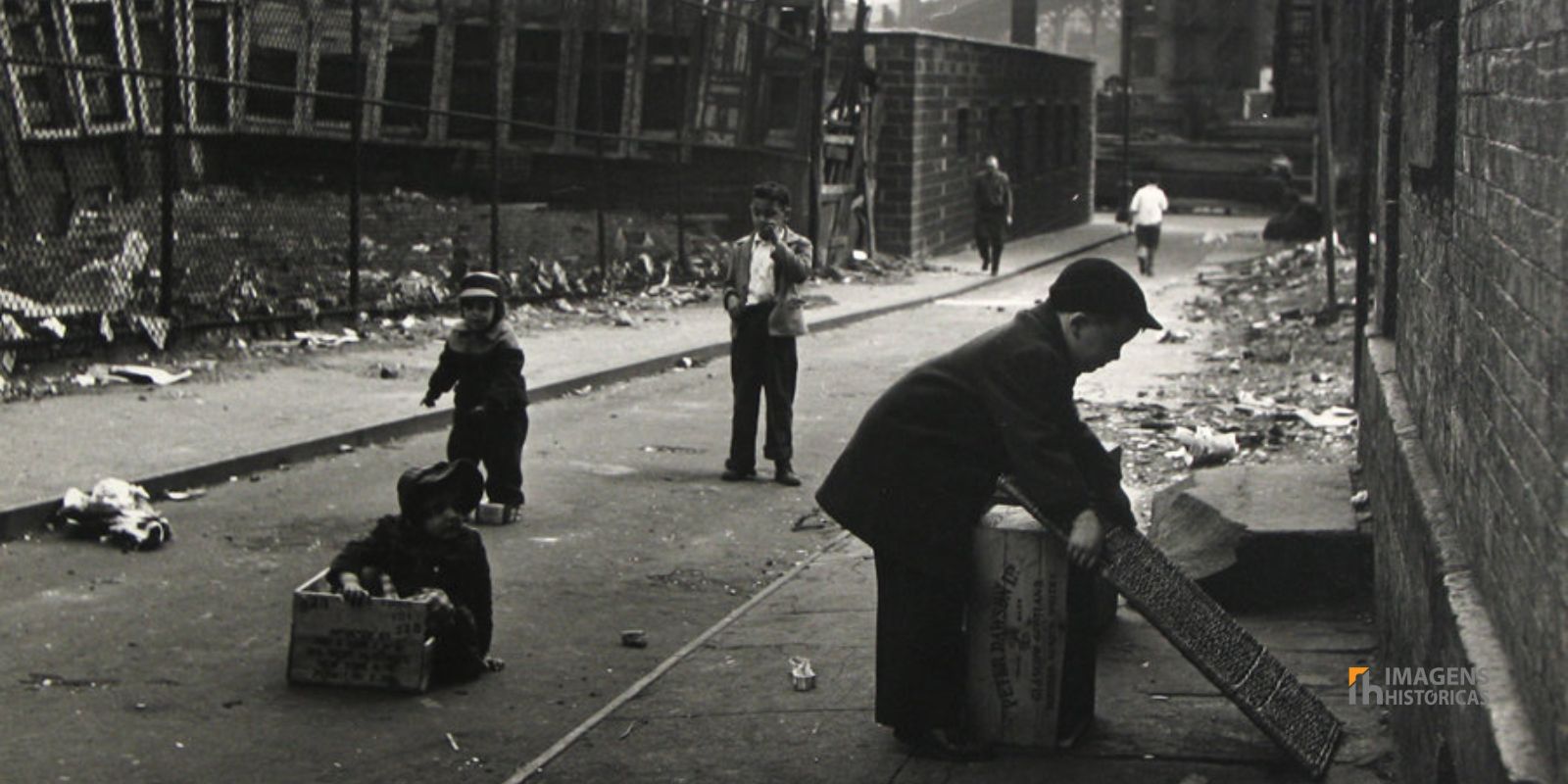 Em meio à paisagem urbana de Nova York, um homem busca por sustento no lixo. A fotografia, marcada pelo contraste social, reflete o compromisso da Photo League em documentar a dura realidade da Grande Depressão. Autor/Fonte: The New York Times.