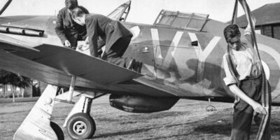 Três armeiros, chamados de “plumbers” (encanadores), recarregam oito metralhadoras dos aviões Hurricane com cinturões de munição. Cada arma é municiada com 300 balas, o suficiente para durar até 15 segundos de disparo. Cada avião da Royal Air Force (Força Aérea Real Britânica) possuía até doze homens em terra responsáveis pela sua manutenção.