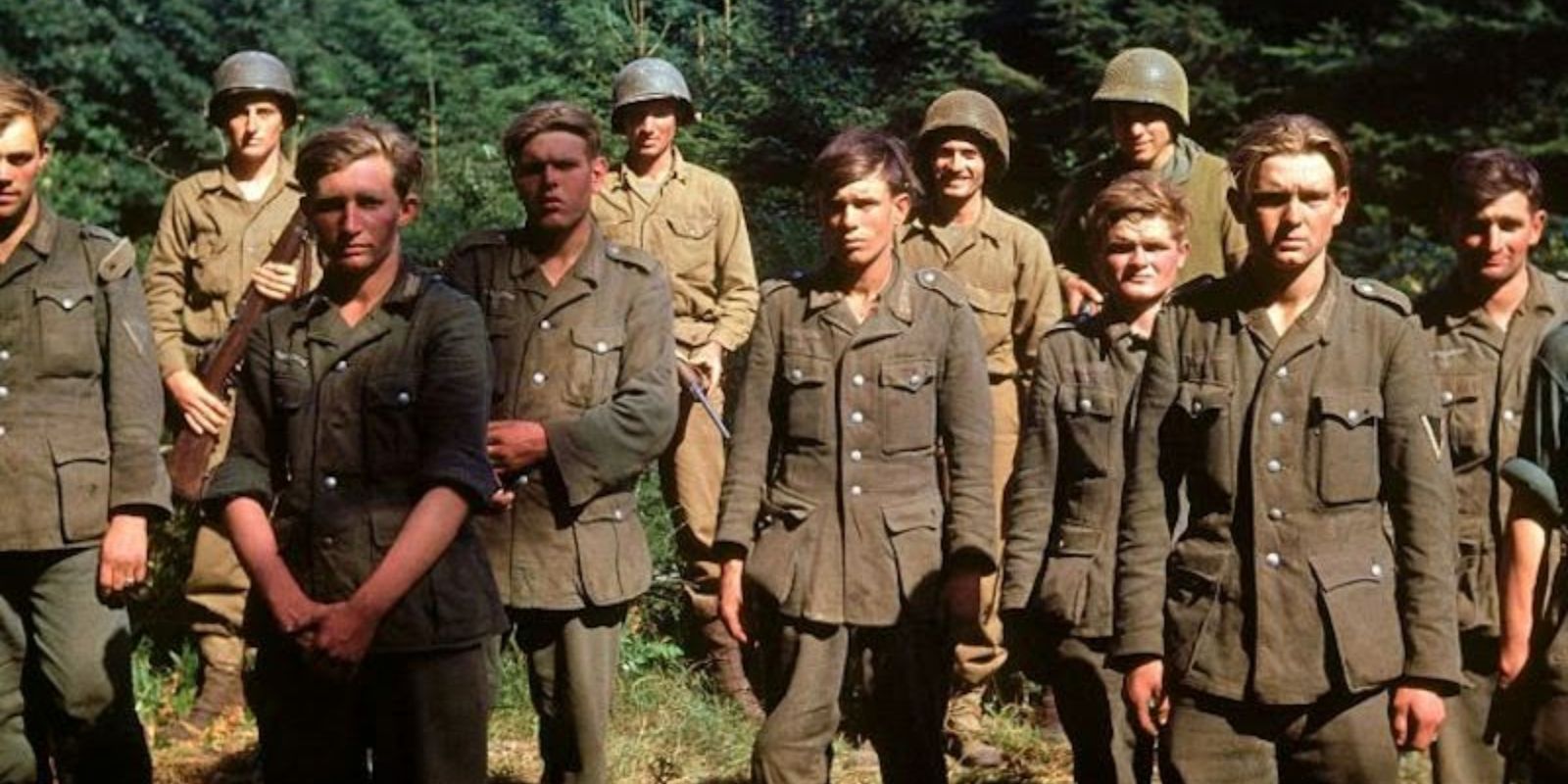 Um grupo de prisioneiros de guerra alemães é reunido após sua captura em junho de 1944. Seus rostos jovens e expressões cansadas, revelados com clareza pela fotografia colorida, humanizam o inimigo e servem como um lembrete da tragédia da guerra. Frank Scherschel / LIFE Picture Collection.