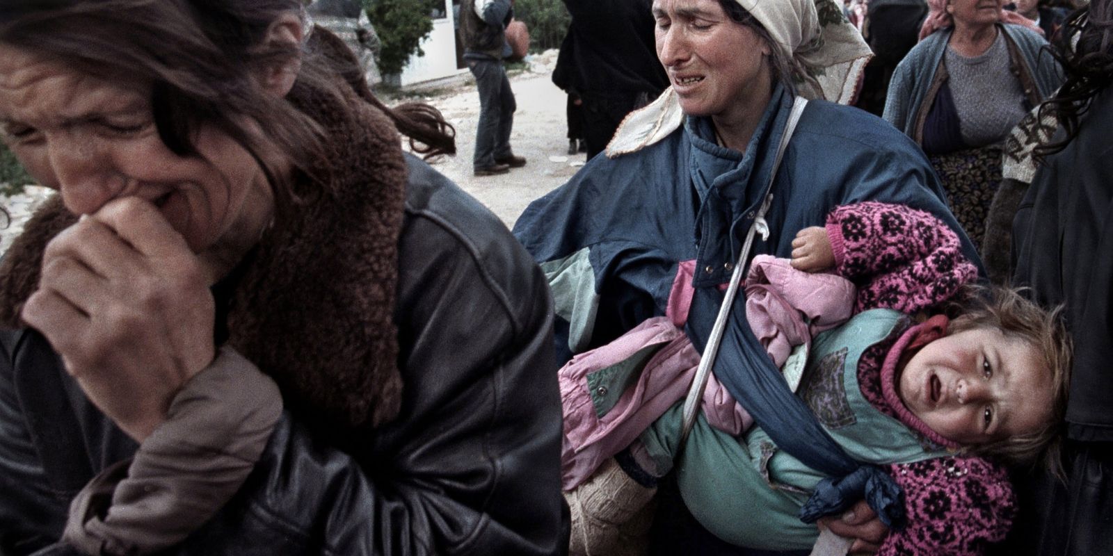 Uma mulher kosovar chora de desespero e alívio ao cruzar a fronteira para a Albânia em 1999. As famílias enfrentaram jornadas perigosas e muitas foram separadas durante a fuga da violência em sua terra natal. Fonte: Carol Guzy / The Washington Post.
