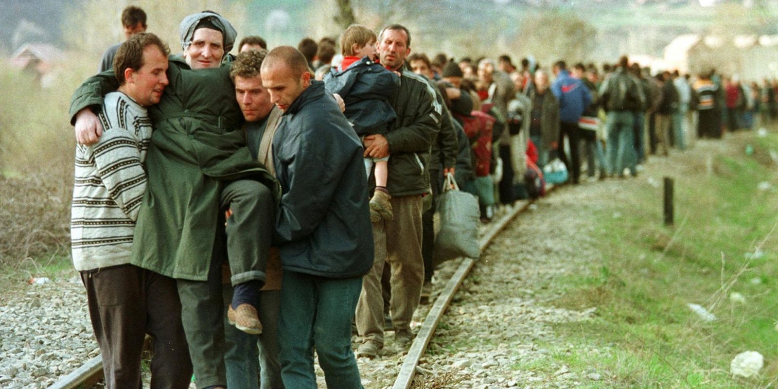 Refugiados de etnia albanesa do Kosovo caminham por uma linha de trem em 1999, fugindo da campanha de limpeza étnica promovida pelas forças sérvias. O êxodo em massa levou mais de 800.000 pessoas a buscar refúgio em países vizinhos. Fonte: Santiago Lyon / Associated Press.