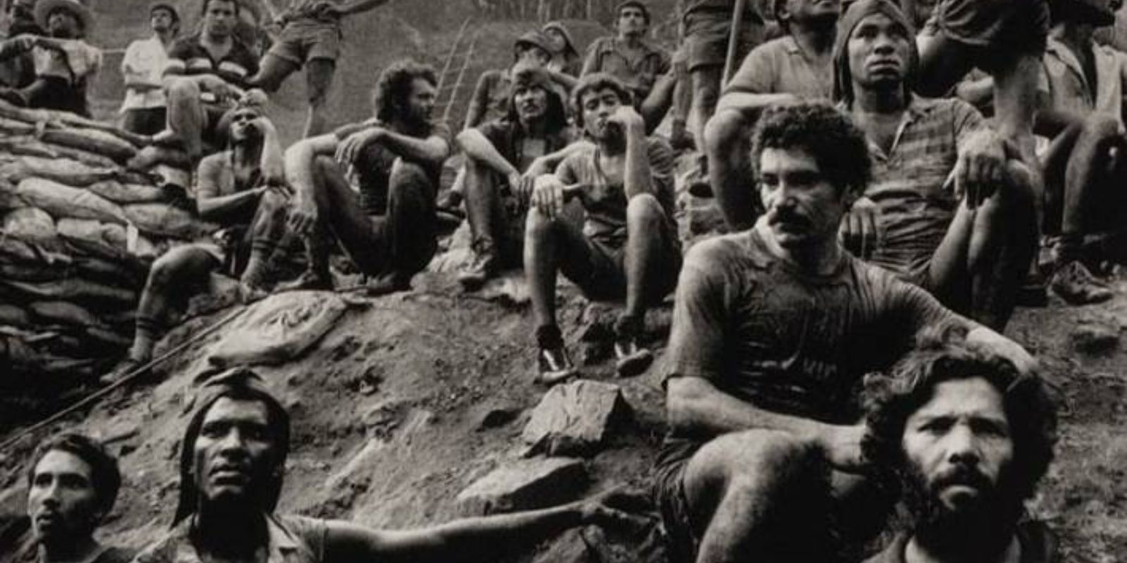 Um grupo de garimpeiros descansa em meio ao trabalho exaustivo. A imagem de Sebastião Salgado captura um momento de camaradagem e humanidade em meio à dureza do garimpo. Autor: Sebastião Salgado.