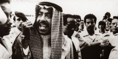 O sheik Fahad Al-Ahmad Al-Sabah gesticula furiosamente em campo, confrontando o árbitro Miroslav Stupar e exigindo a anulação do gol da França durante a partida da Copa do Mundo de 1982.