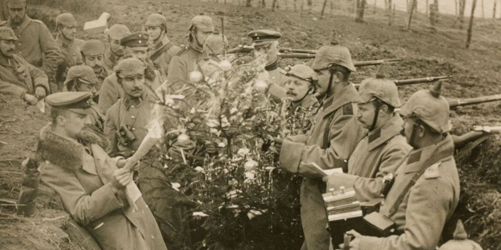 Soldados alemães posam com uma pequena árvore de Natal em sua trincheira durante o período da Trégua de Natal. A tradição alemã de decorar árvores foi um dos catalisadores para o início da trégua.