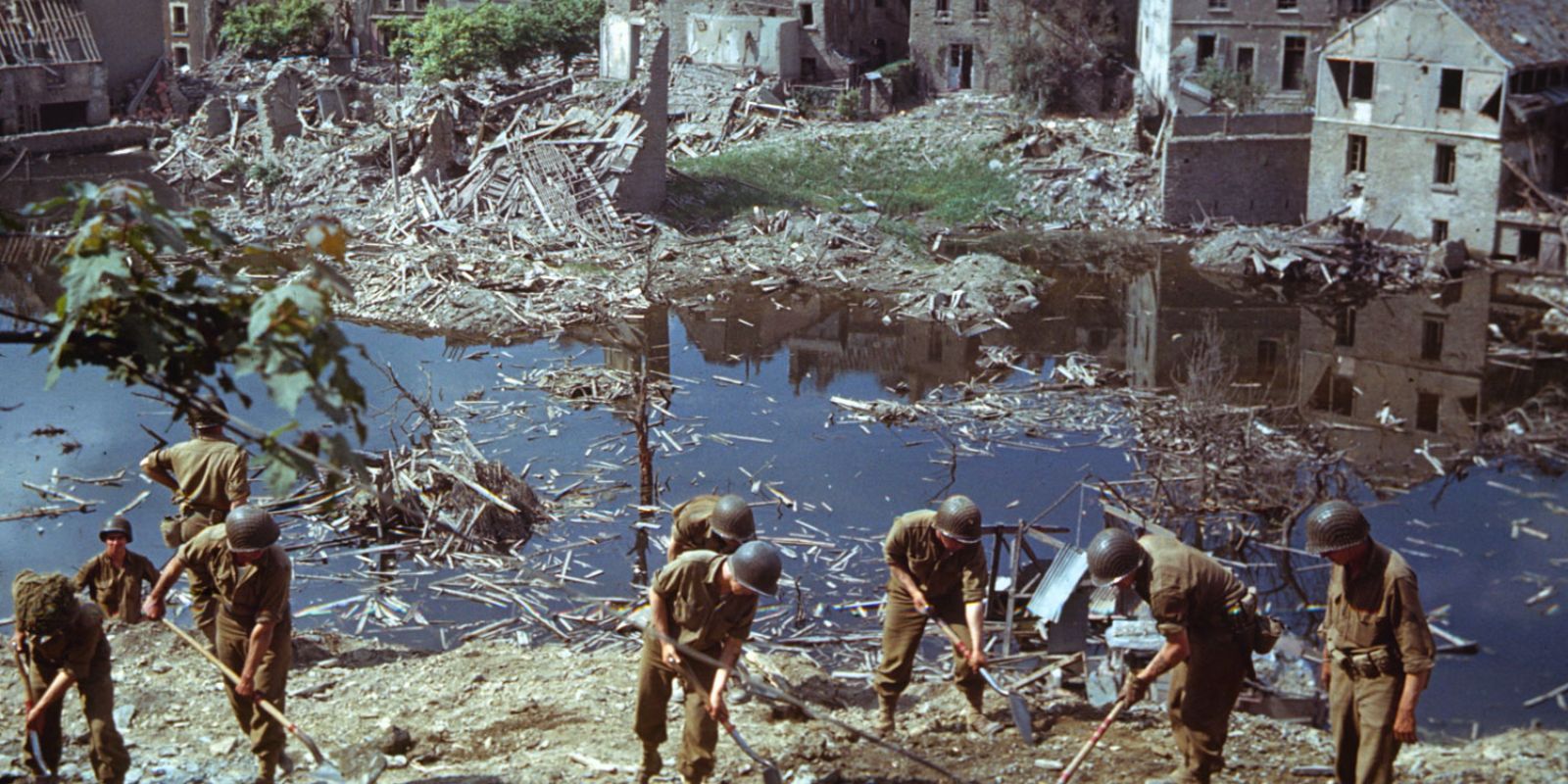 Soldados americanos trabalham em meio à devastação de uma cidade na Normandia, no verão de 1944. A fotografia colorida de Frank Scherschel para a LIFE expõe a destruição causada pelos combates e o custo da libertação. Fonte: Frank Scherschel / LIFE Picture Collection.
