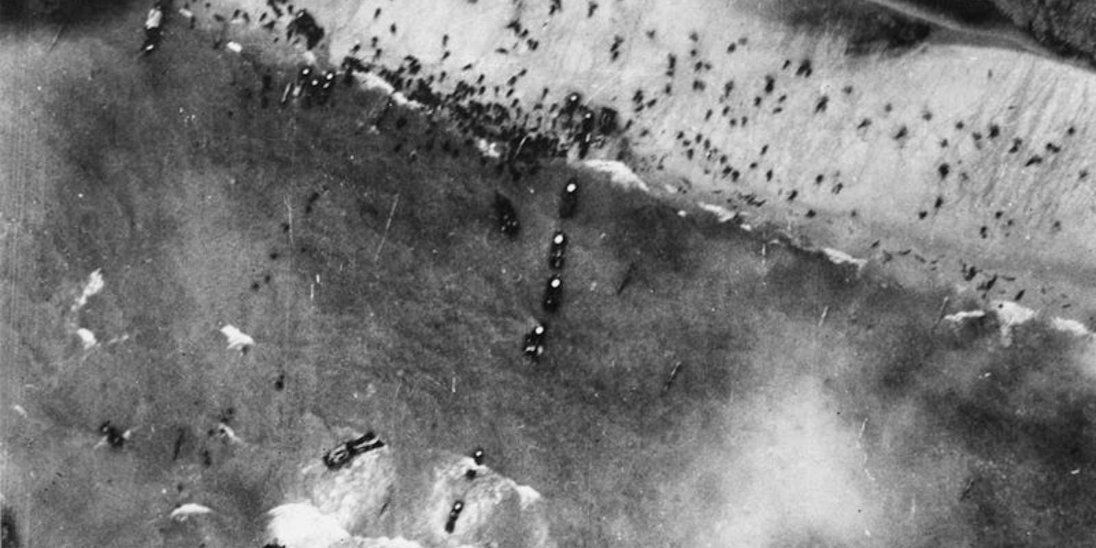 Uma vista aérea da frota de invasão aliada no Canal da Mancha no Dia D. Centenas de navios de guerra, transportes de tropas e embarcações de desembarque se estendem até o horizonte, demonstrando a escala monumental da Operação Overlord. Autor: U.S. Air Force.